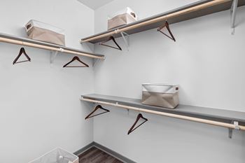 Closet with three shelves and two hangers at The Quinn Luxury Apartments, Pensacola 32526